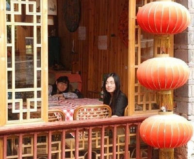 A view from the outside of a pavilion lattice window and hanging lanterns.